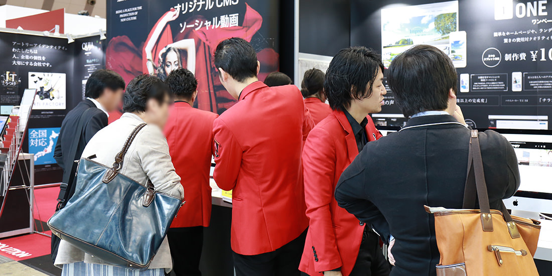 来場者とお話をする赤いジャケットを着たアートリーのスタッフ