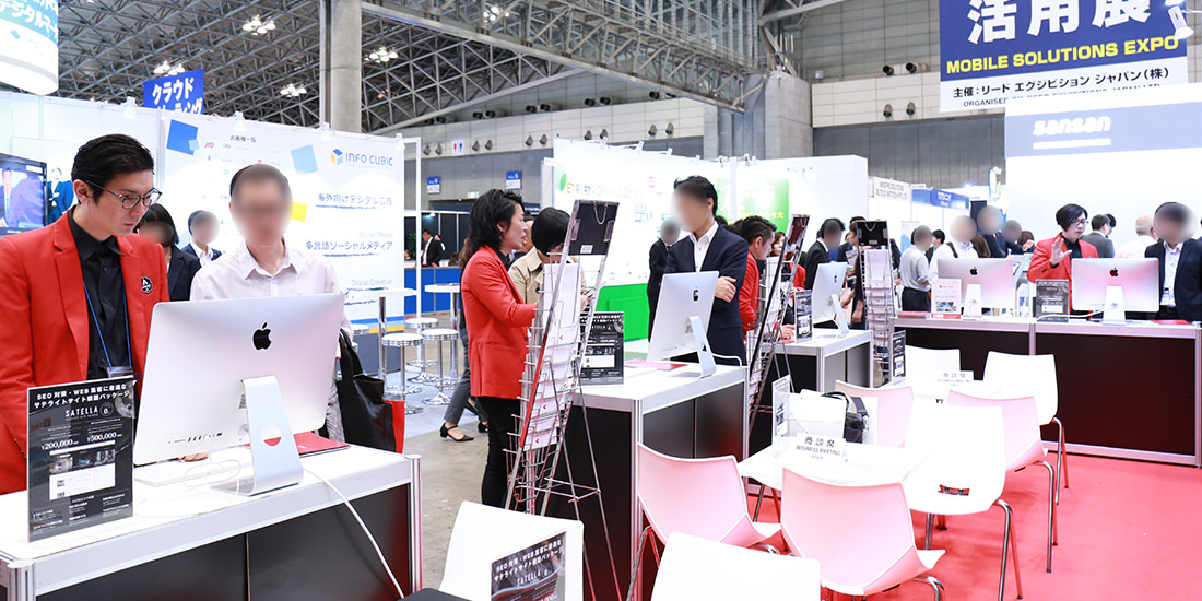 展示会開場にて来場者への接客を行うスタッフ