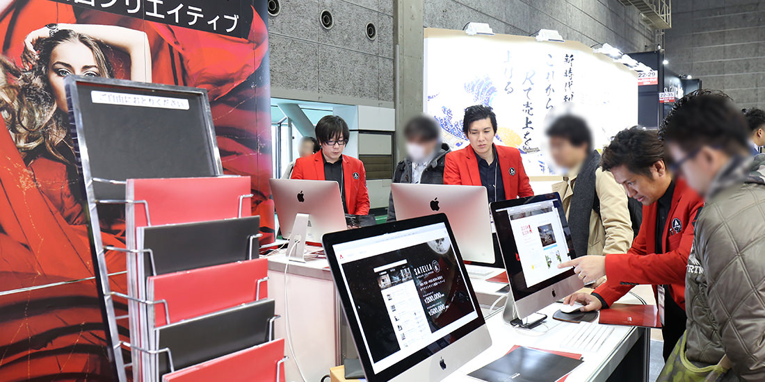 パンフレット＆商品チラシの奥に商談しているスタッフ