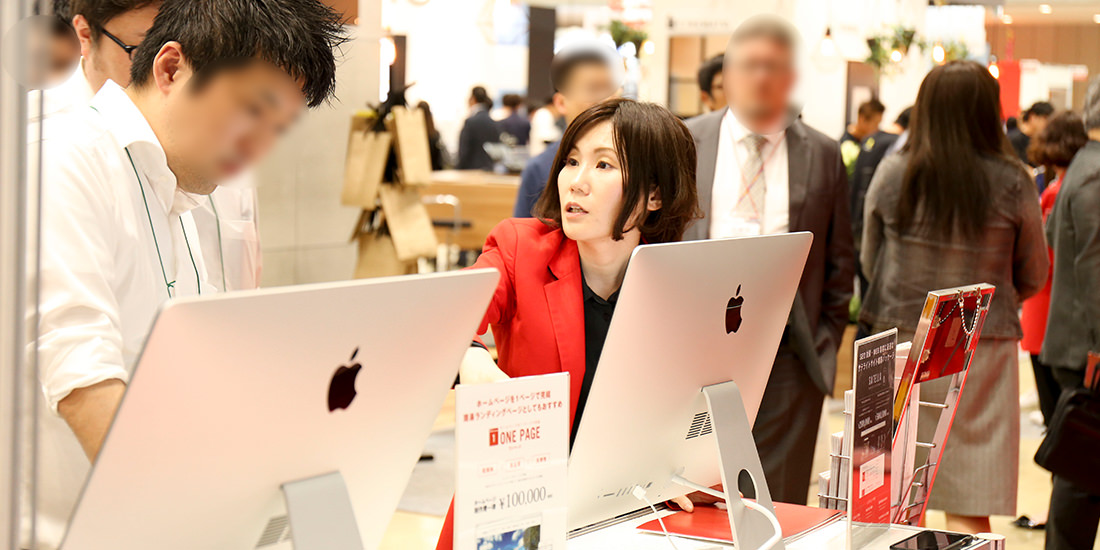 来場者に事業紹介をする