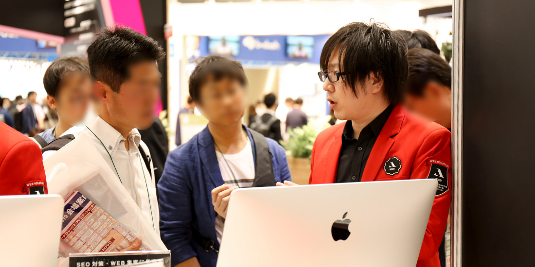 来場者グループに囲まれながら、質問に対応する