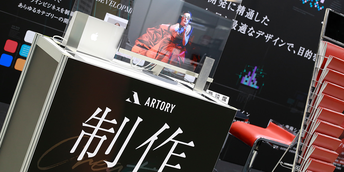 スタッフはアクリル板越しに立ち、モニターを操作しながら商談をする