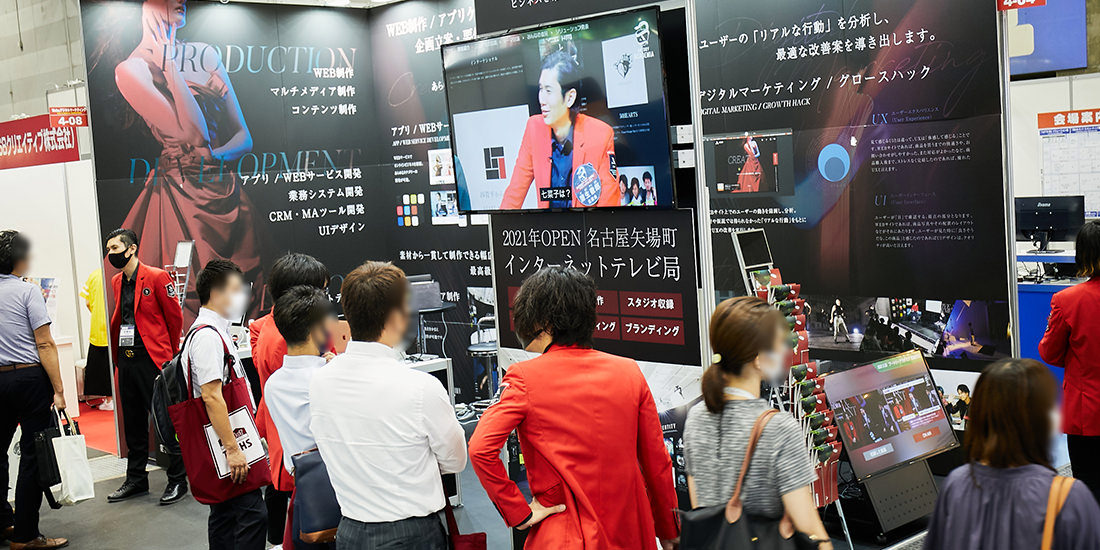 モニターで流れているアートリーアカデミアが来場者の注目を集める