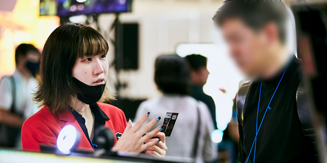 名刺交換をして来場者様の業種を伺うプロデューサー